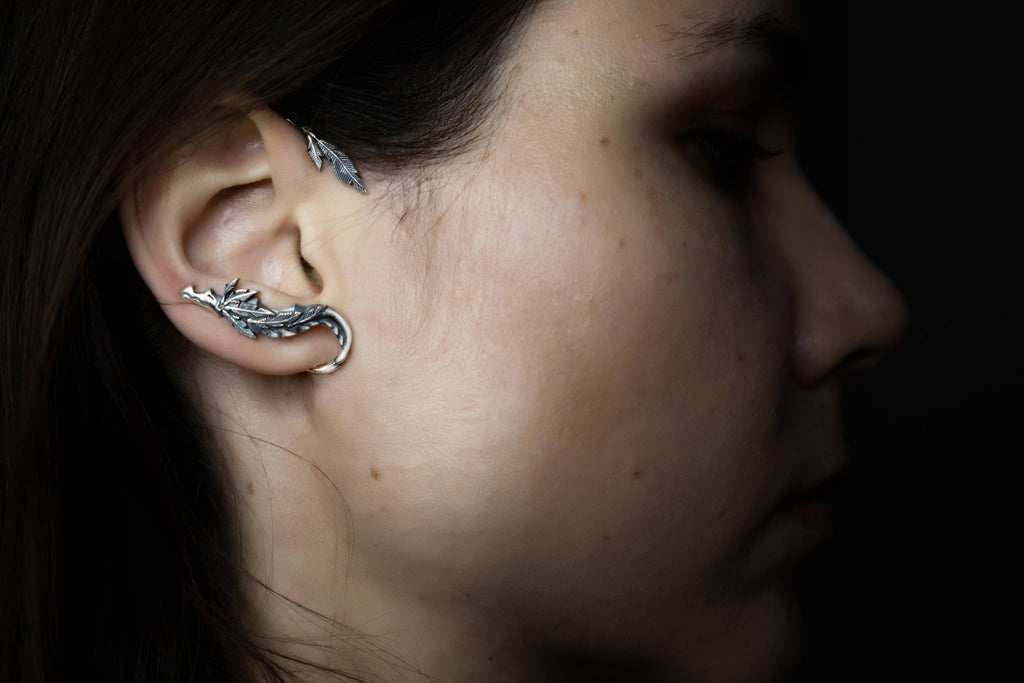 Silver Quetzalcoatl ear cuff wrapped around ear, Aztec serpent jewelry