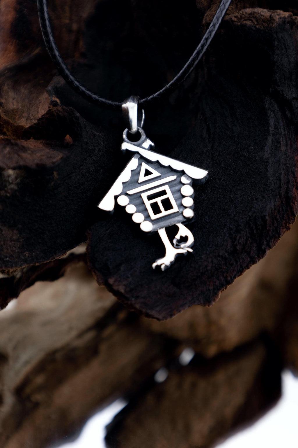 Pendant of hut on chicken legs against forest-themed setup