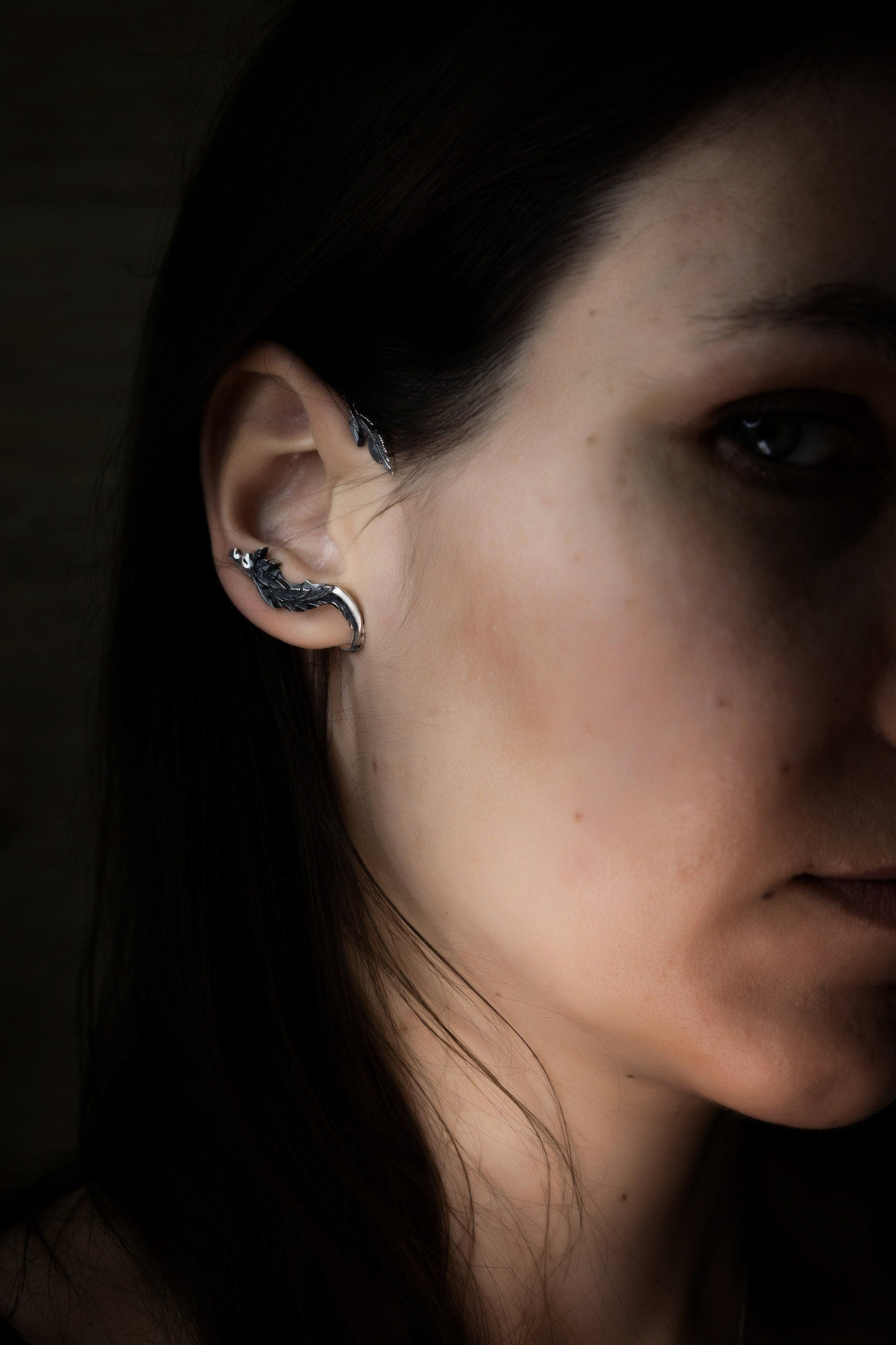 Fantasy silver ear cuff shaped like Quetzalcoatl serpent