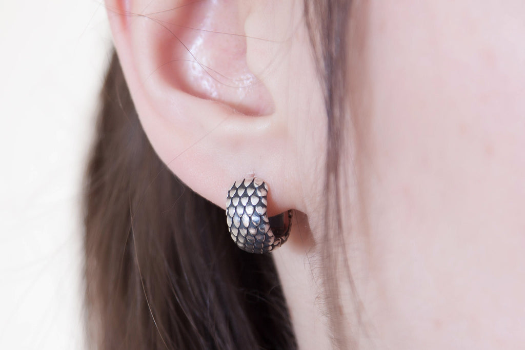 Silver hoop earring worn on ear