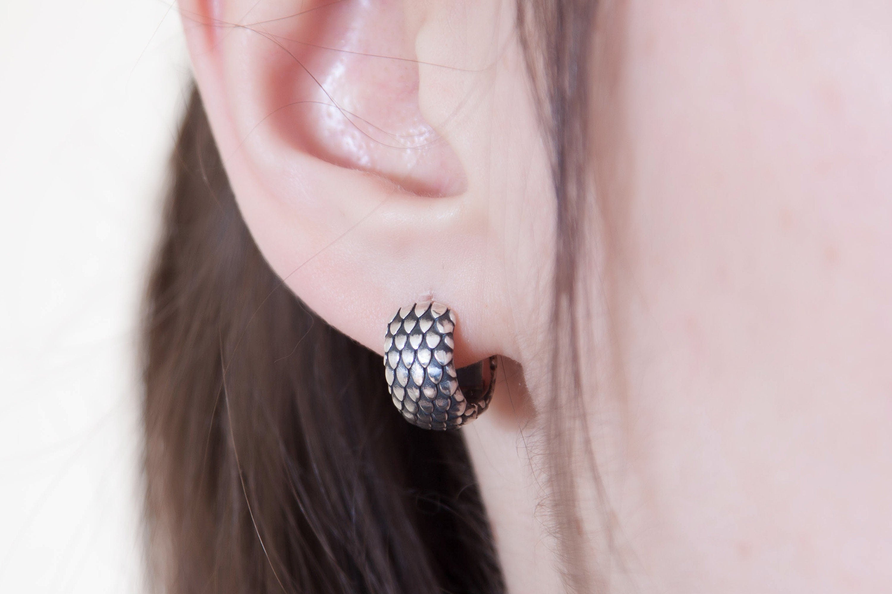 Silver hoop earring worn on ear