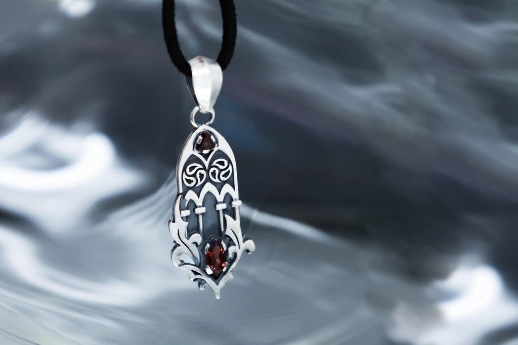 Openwork cathedral inspired silver pendant with garnet