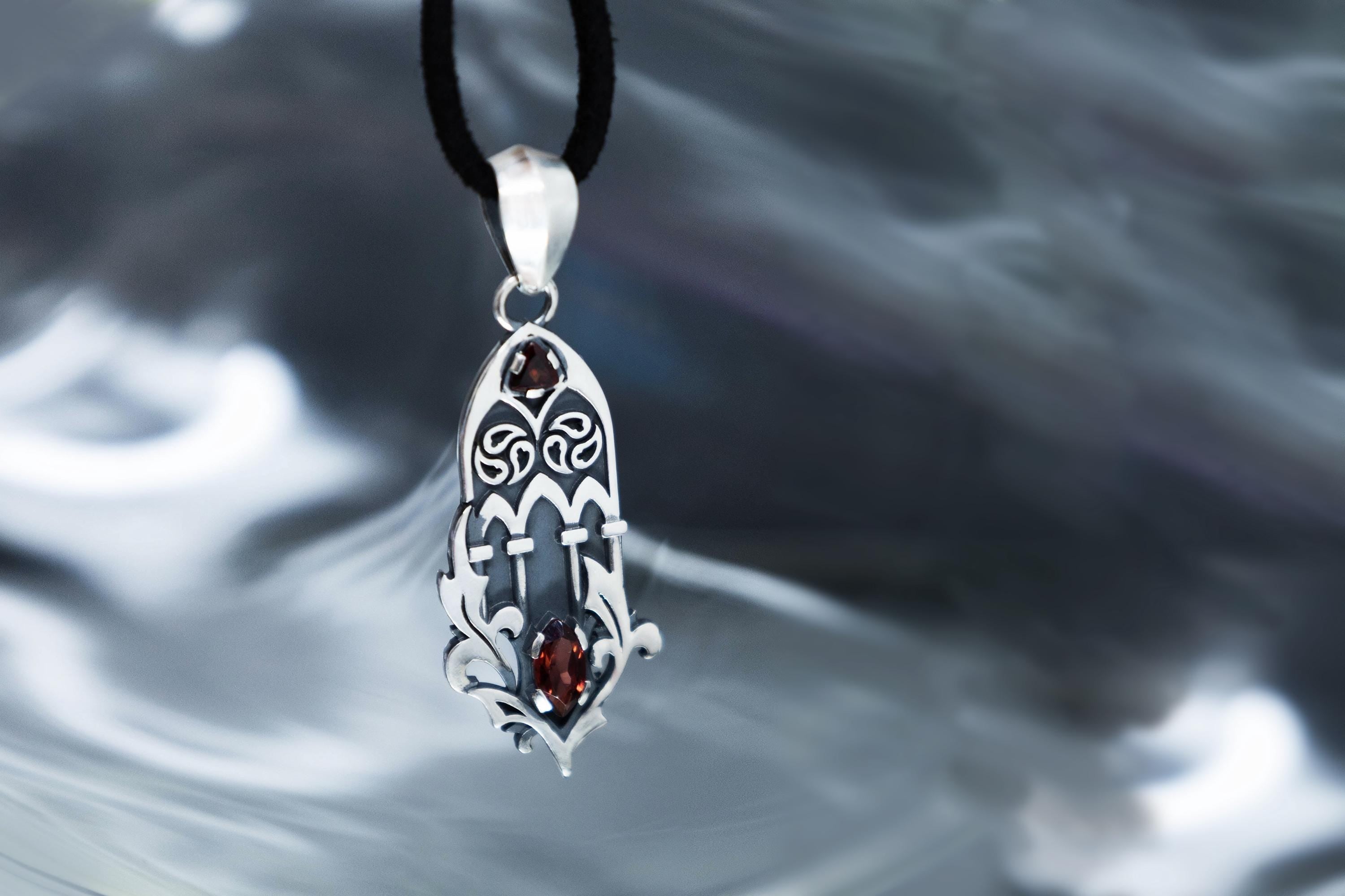 Openwork cathedral inspired silver pendant with garnet