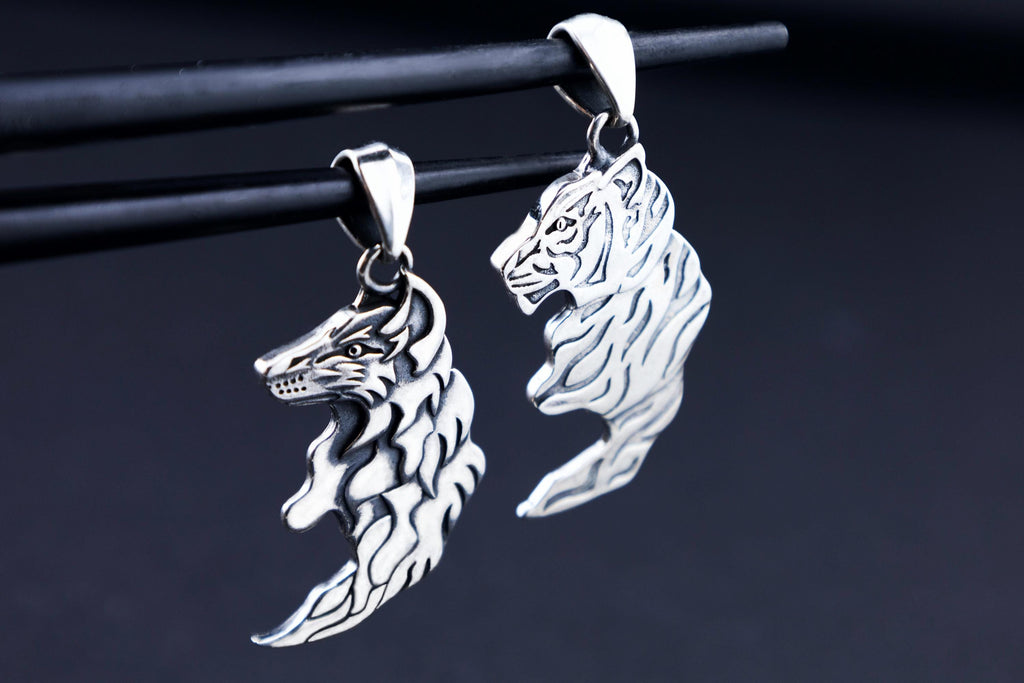 Wolf and tiger pendants forming yin-yang inspired pair