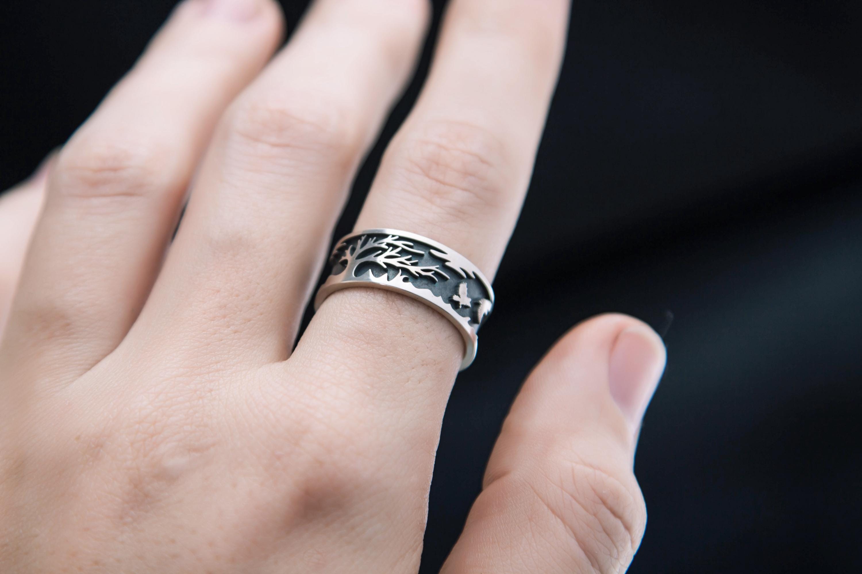 Hand wearing tree and raven sterling silver ring