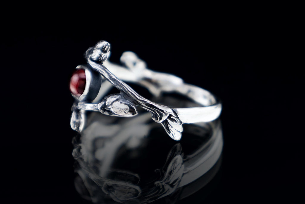 Close-up of real branch texture silver ring with garnet
