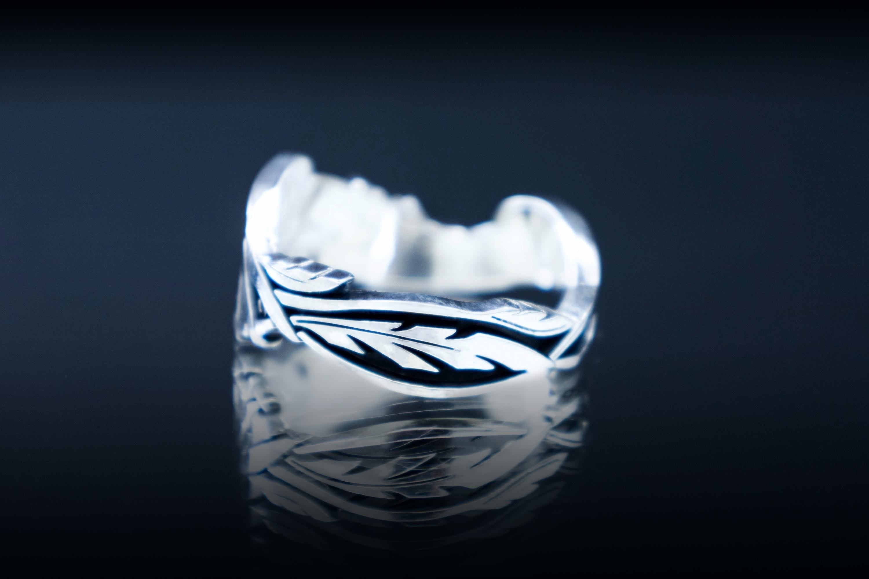 Close-up of Phoenix wing and feather details on silver band