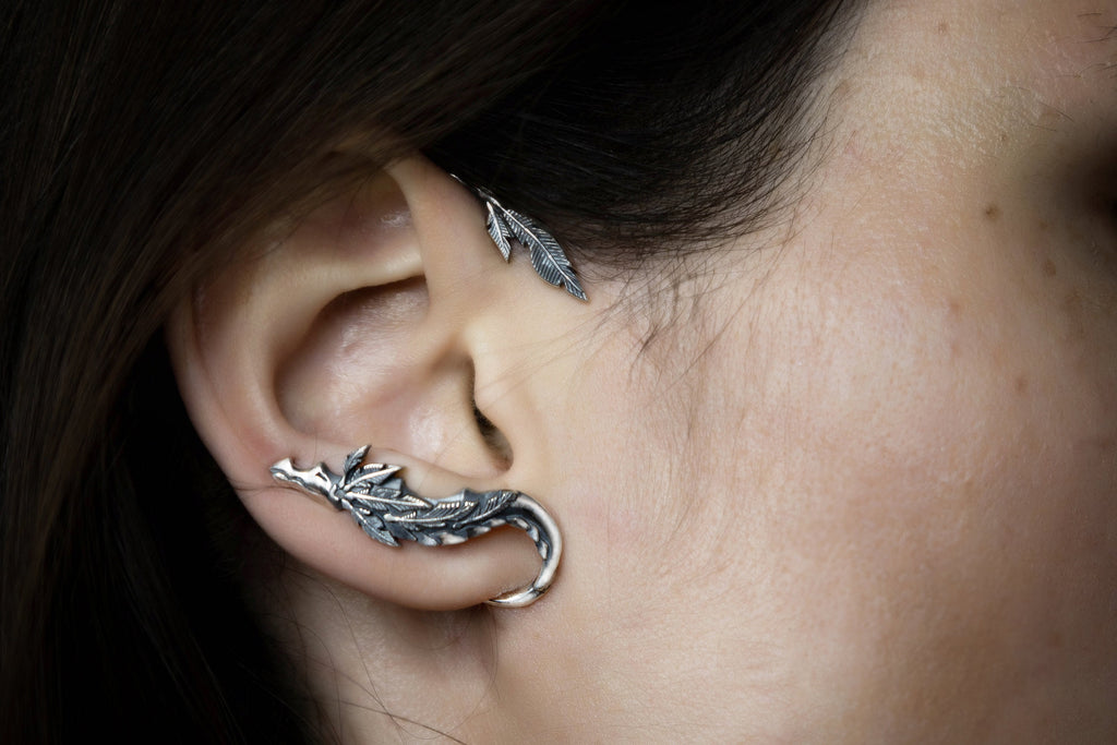 Silver Quetzalcoatl ear cuff wrapped around ear, Aztec serpent jewelry