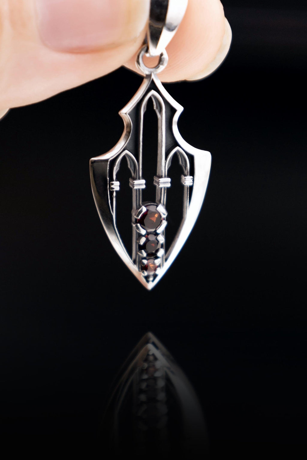 Architectural fantasy talisman with gothic arches and garnet stones