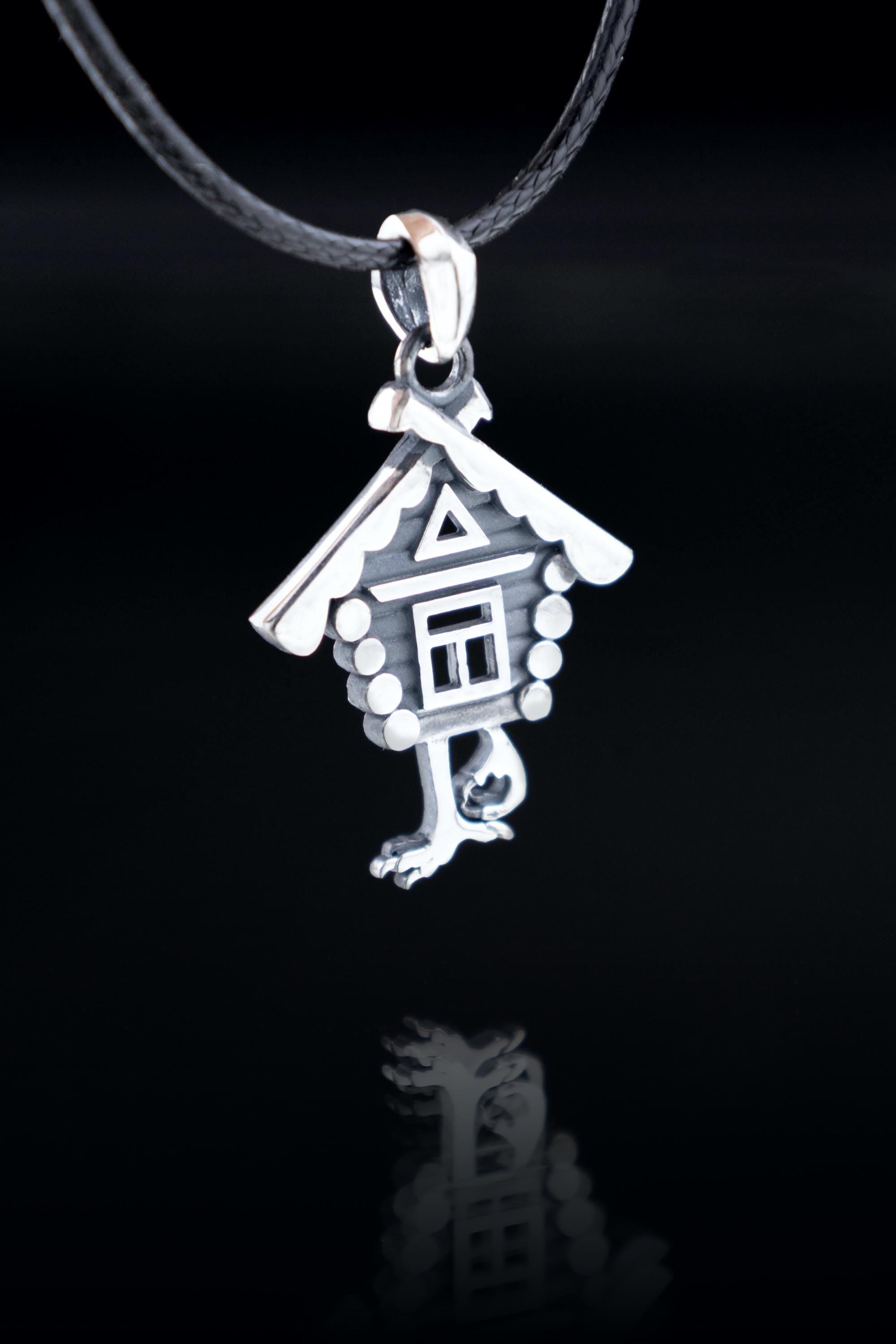 Sterling silver Baba Yaga hut pendant on dark background