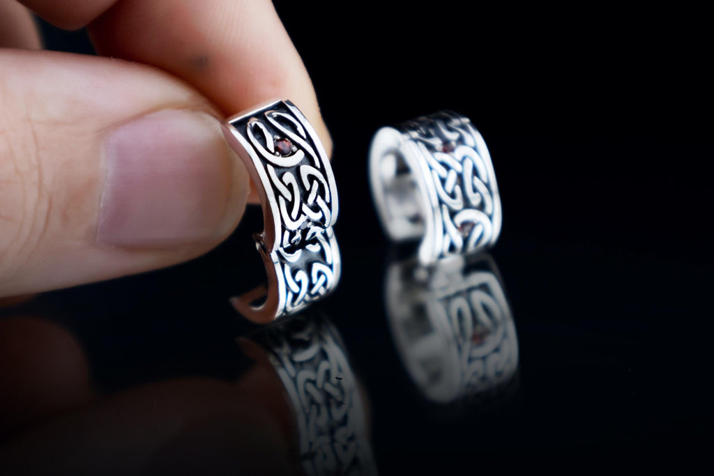 Close up of sterling silver Celtic hoop earrings with garnets