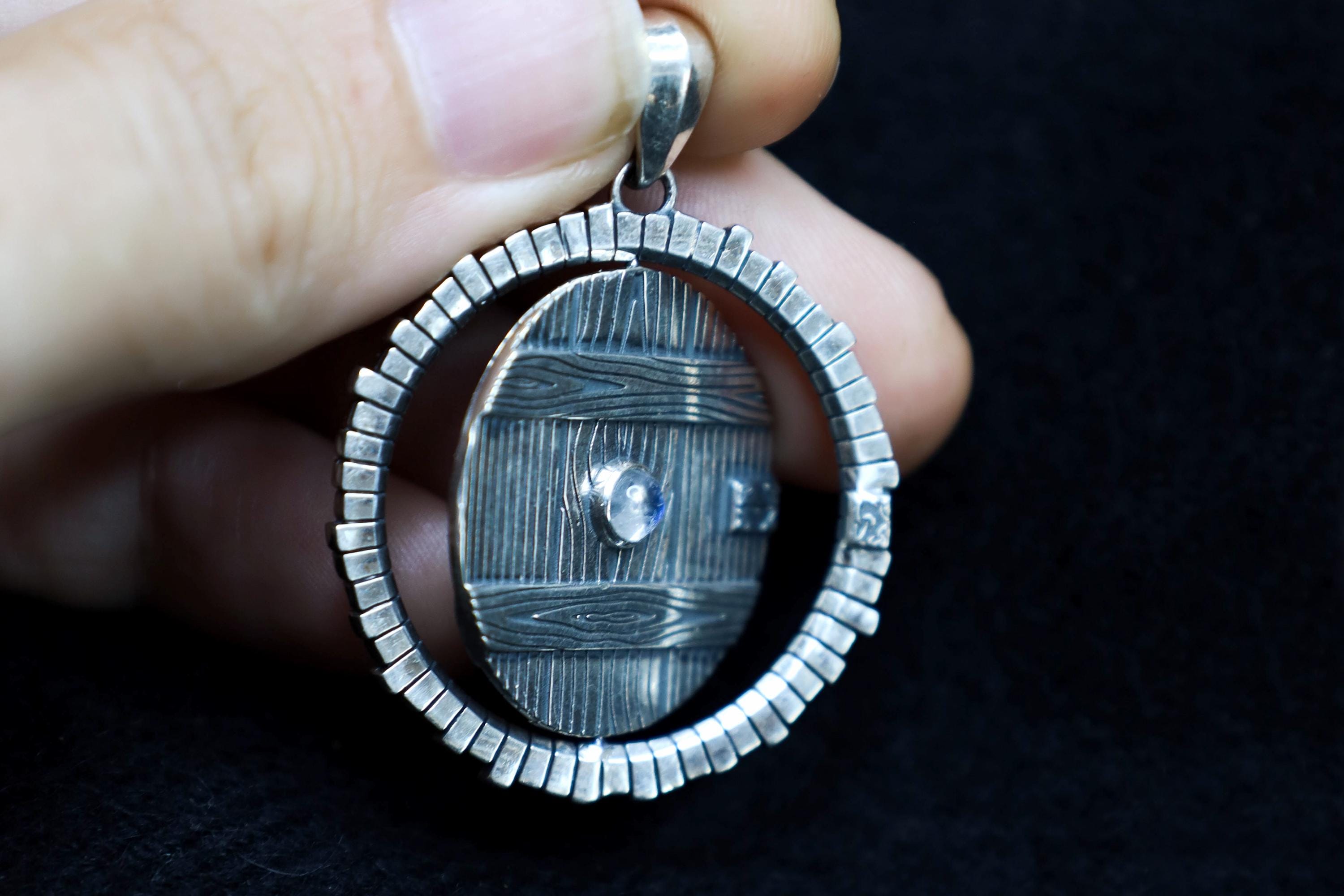 Spinning symbolic door pendant with natural gemstone