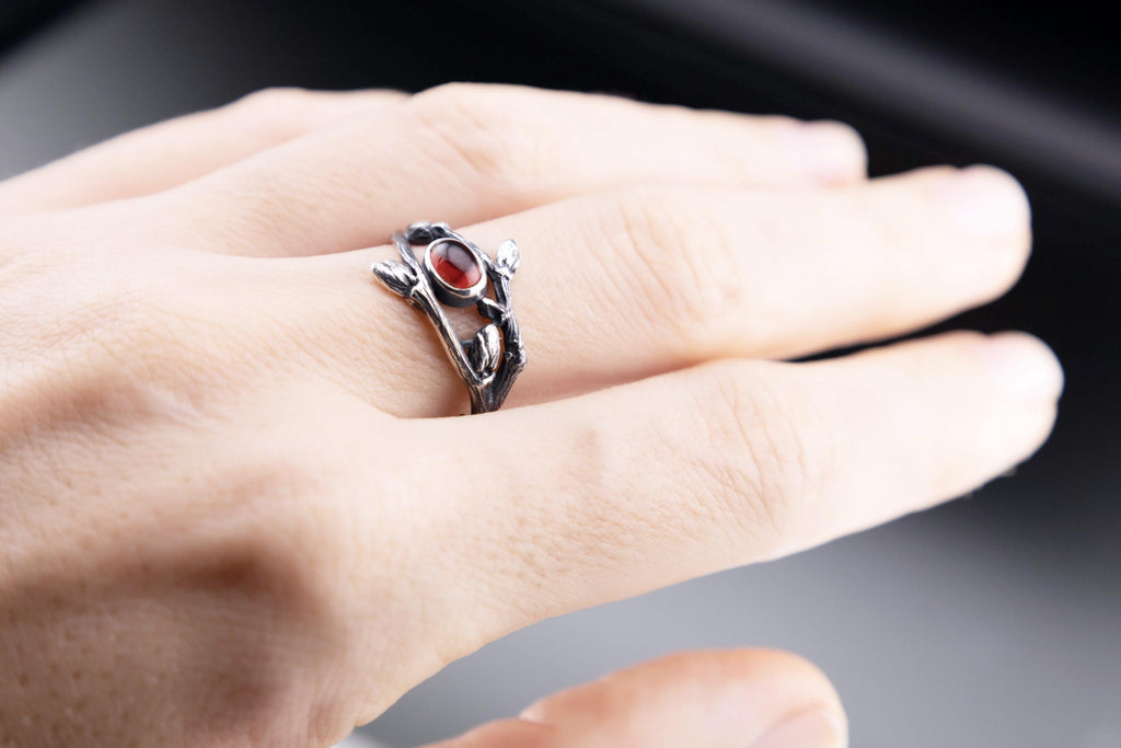 Nature-inspired silver branch ring with garnet in use
