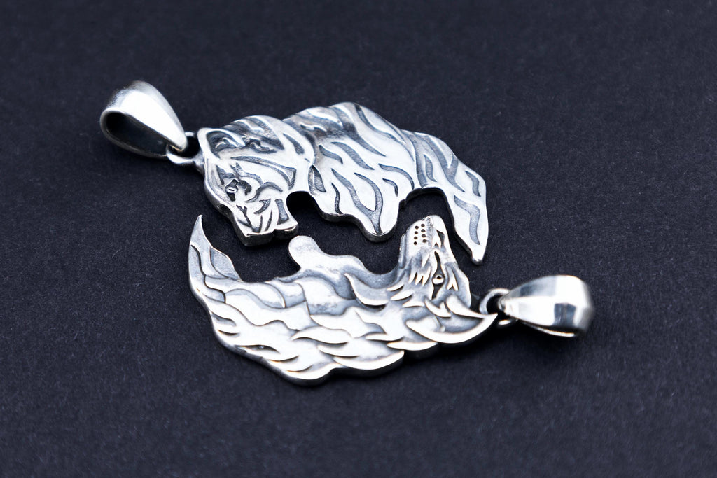 Sterling silver wolf and tiger matching pendants on black background
