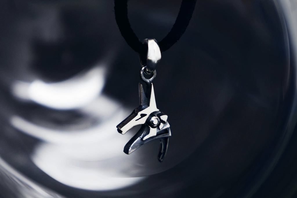 Silver Anubis pendant on dark background, Egyptian god necklace