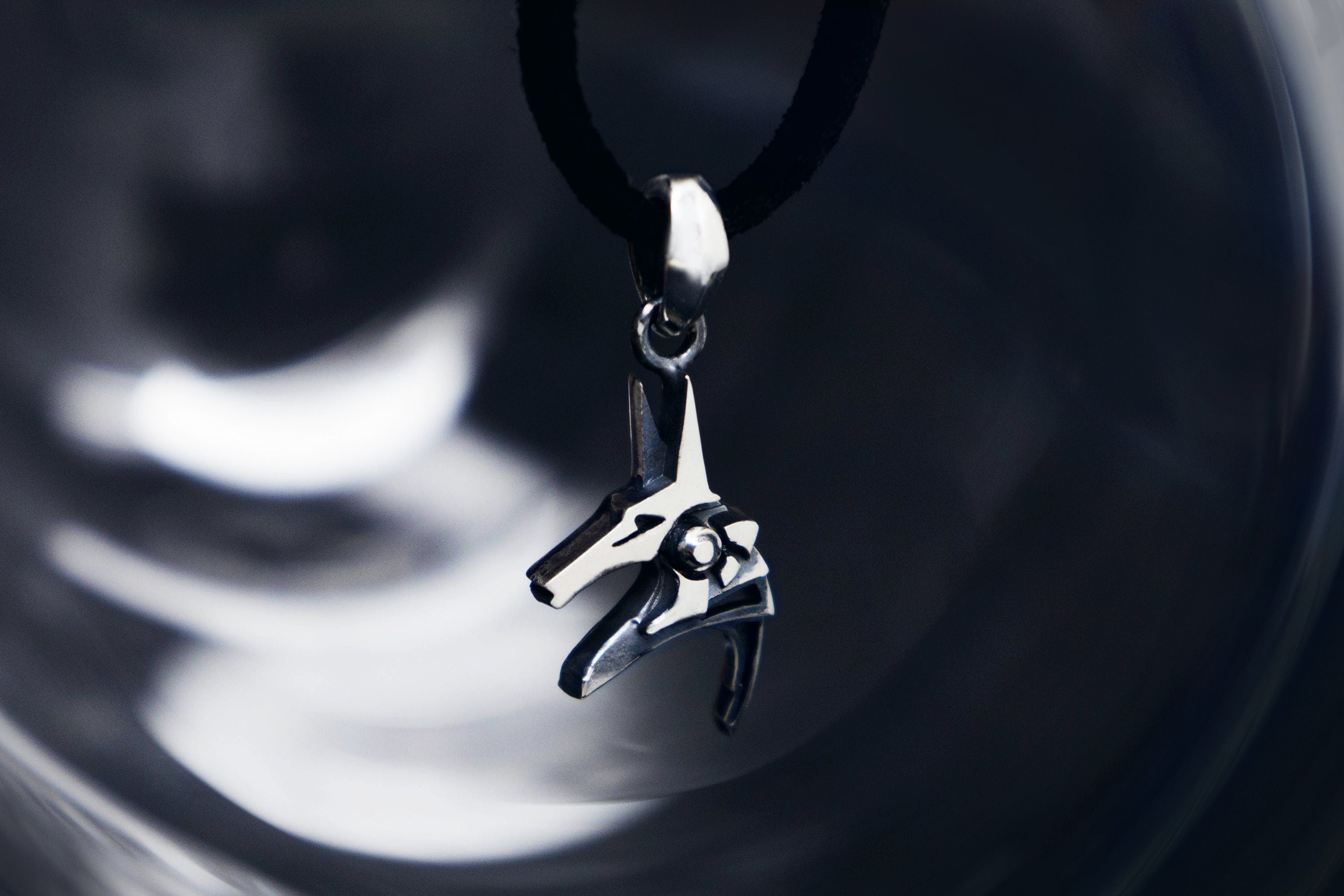 Silver Anubis pendant on dark background, Egyptian god necklace