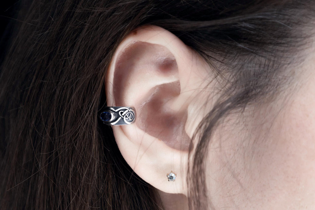 Silver ear cuff on ear with gemstone