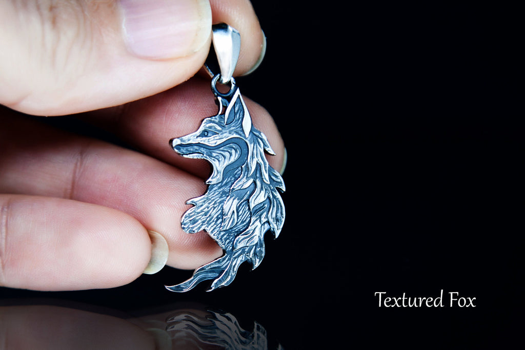 Fox pendant shown in hand for scale
