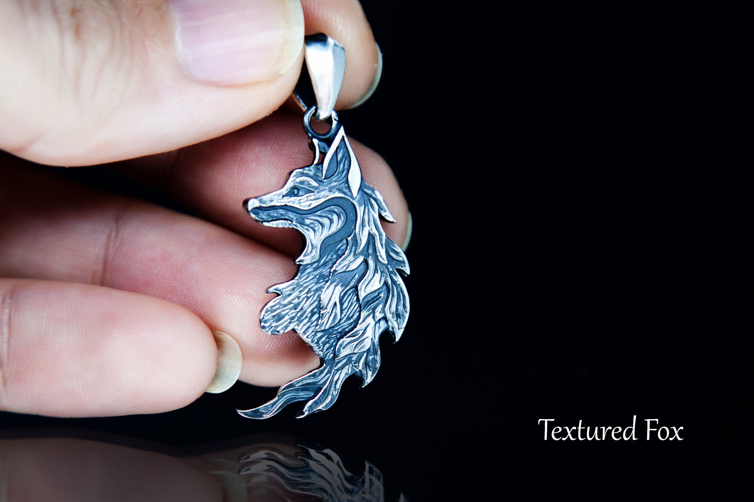 Fox pendant shown in hand for scale