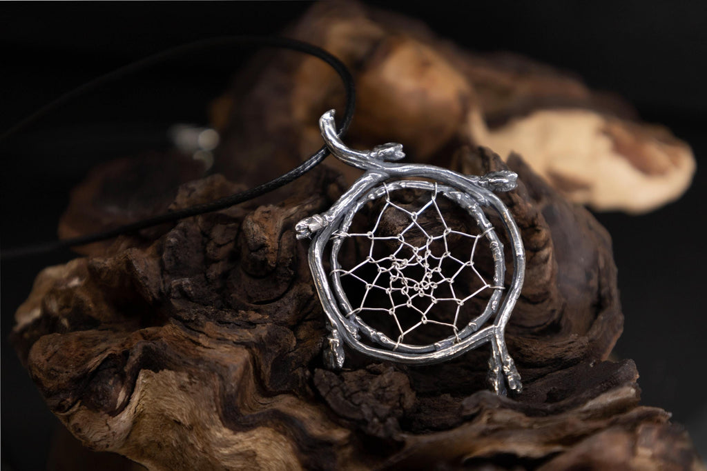 Sterling silver dreamcatcher pendant with branch frame on natural woodland background