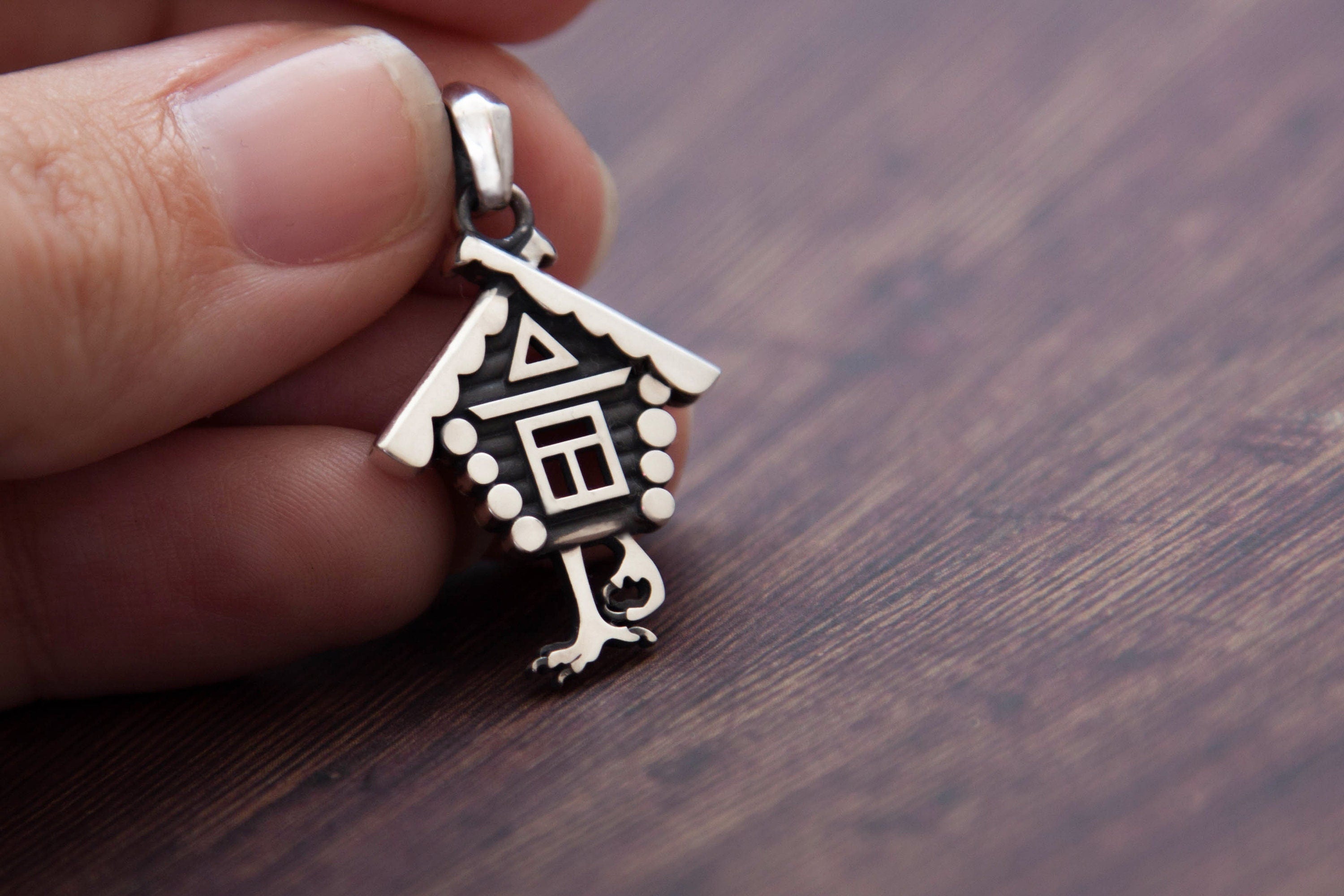 Baba Yaga house necklace styled on wood background