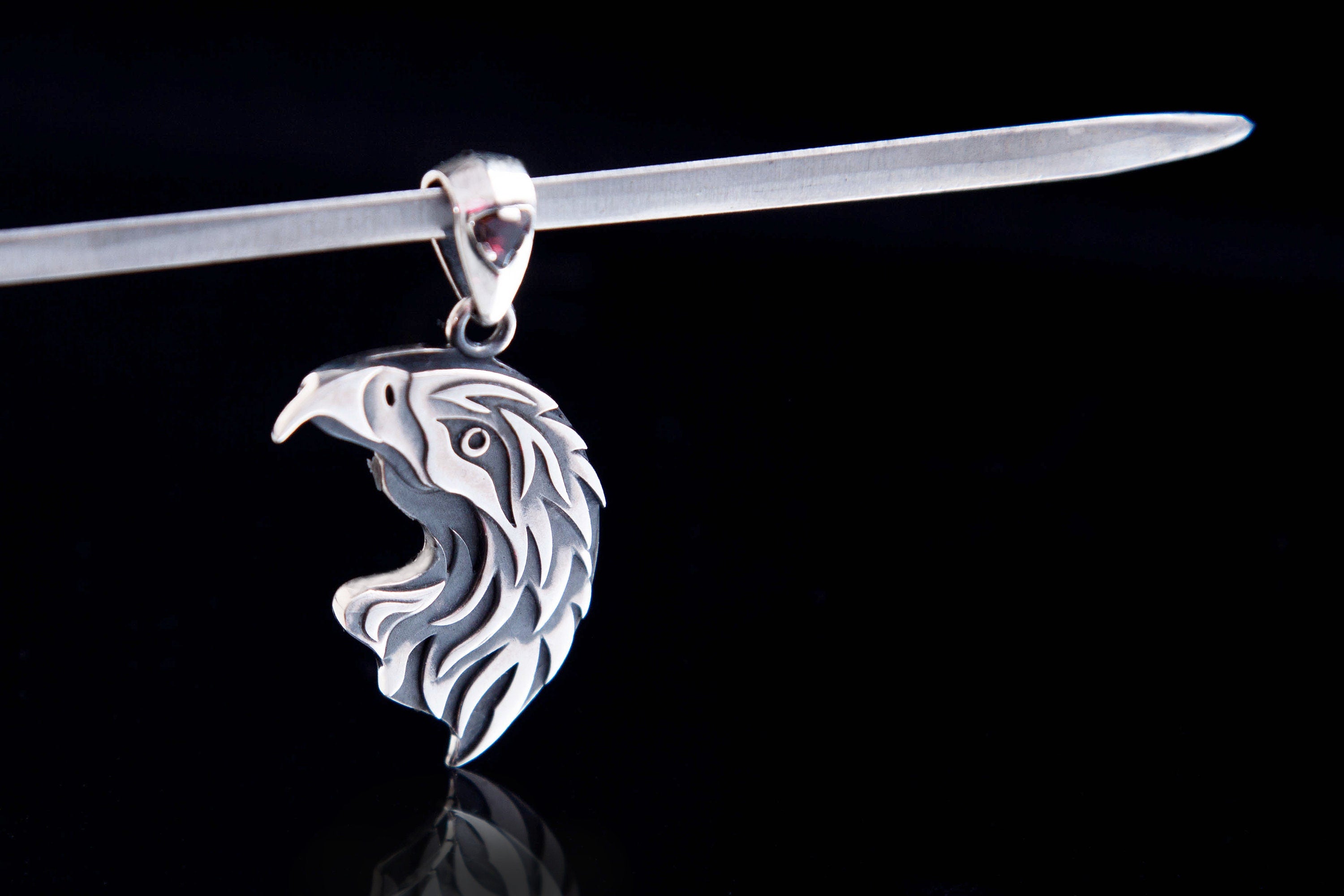 Single eagle silver pendant hanging on a chain, detailed bird of prey design