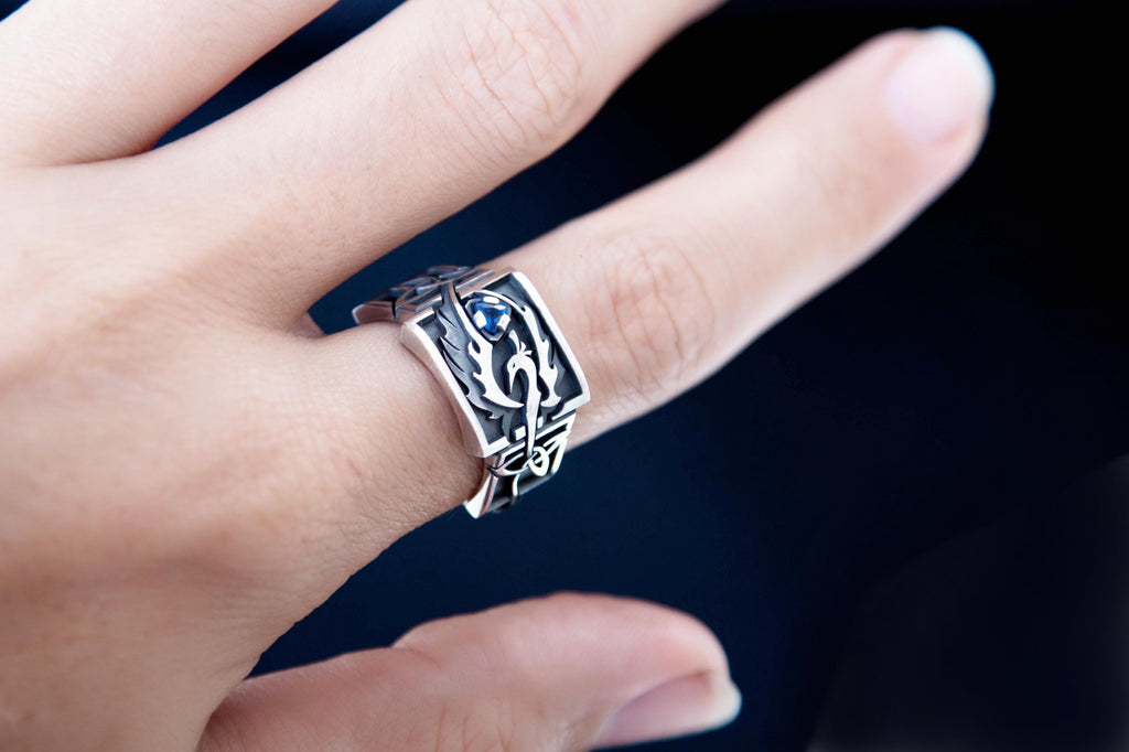 Handmade Celtic phoenix signet ring on hand, blue gemstone