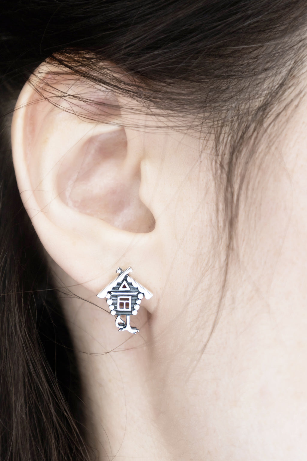 Fairy tale silver stud earrings worn on ear