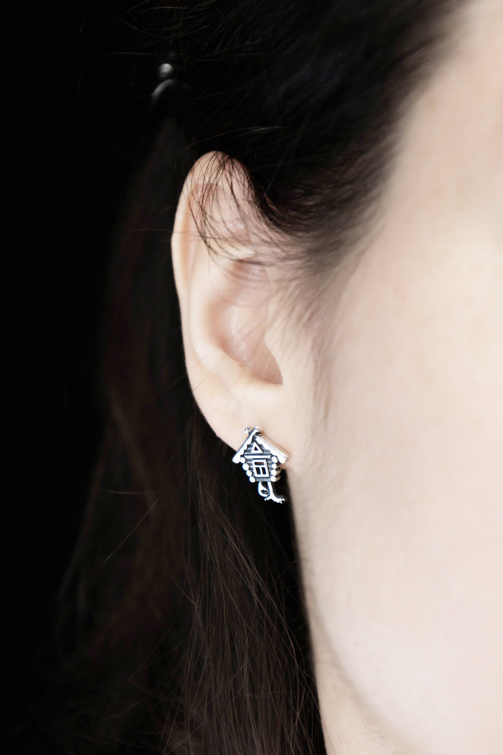 Fairy tale silver stud earrings worn on ear