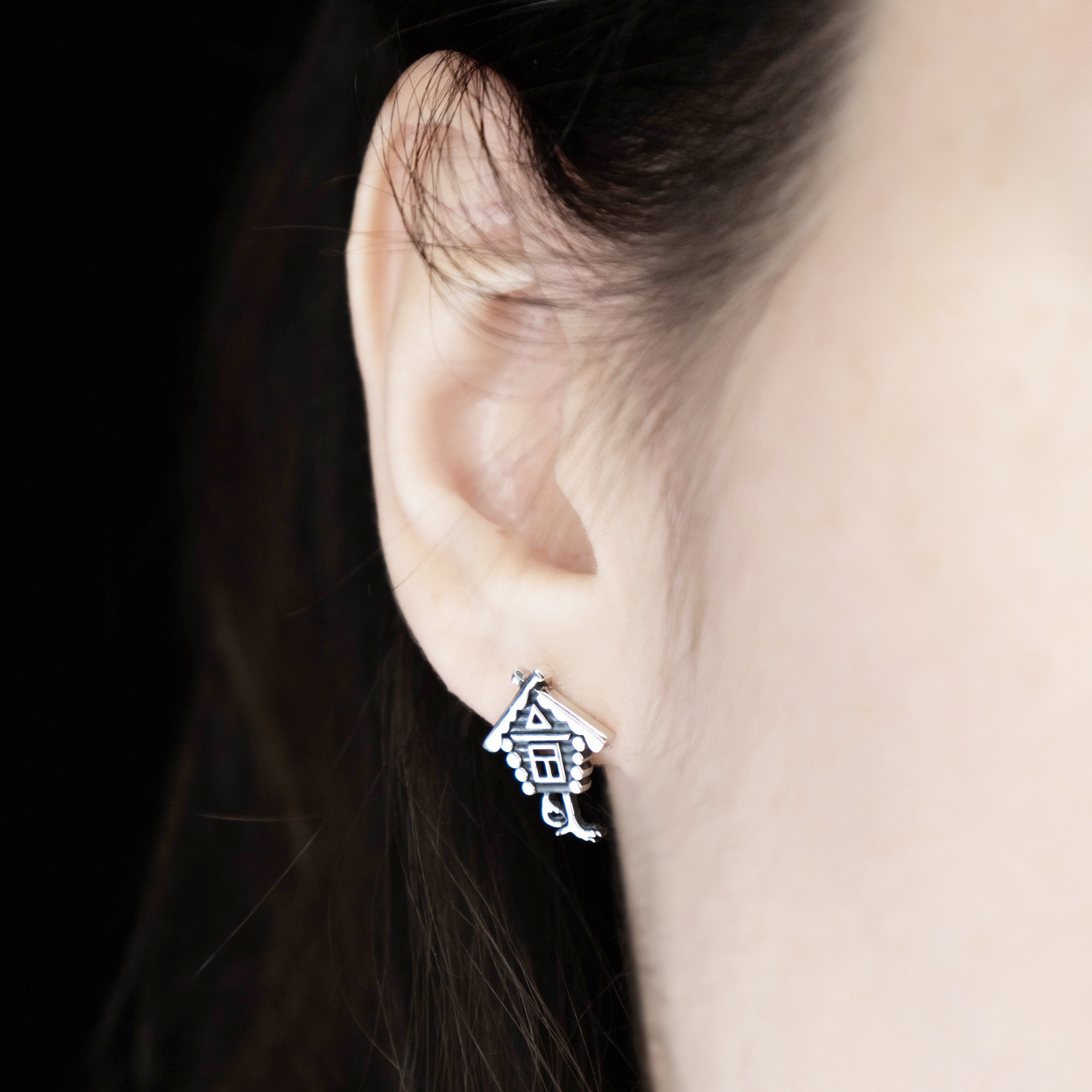 Fairy tale silver stud earrings worn on ear