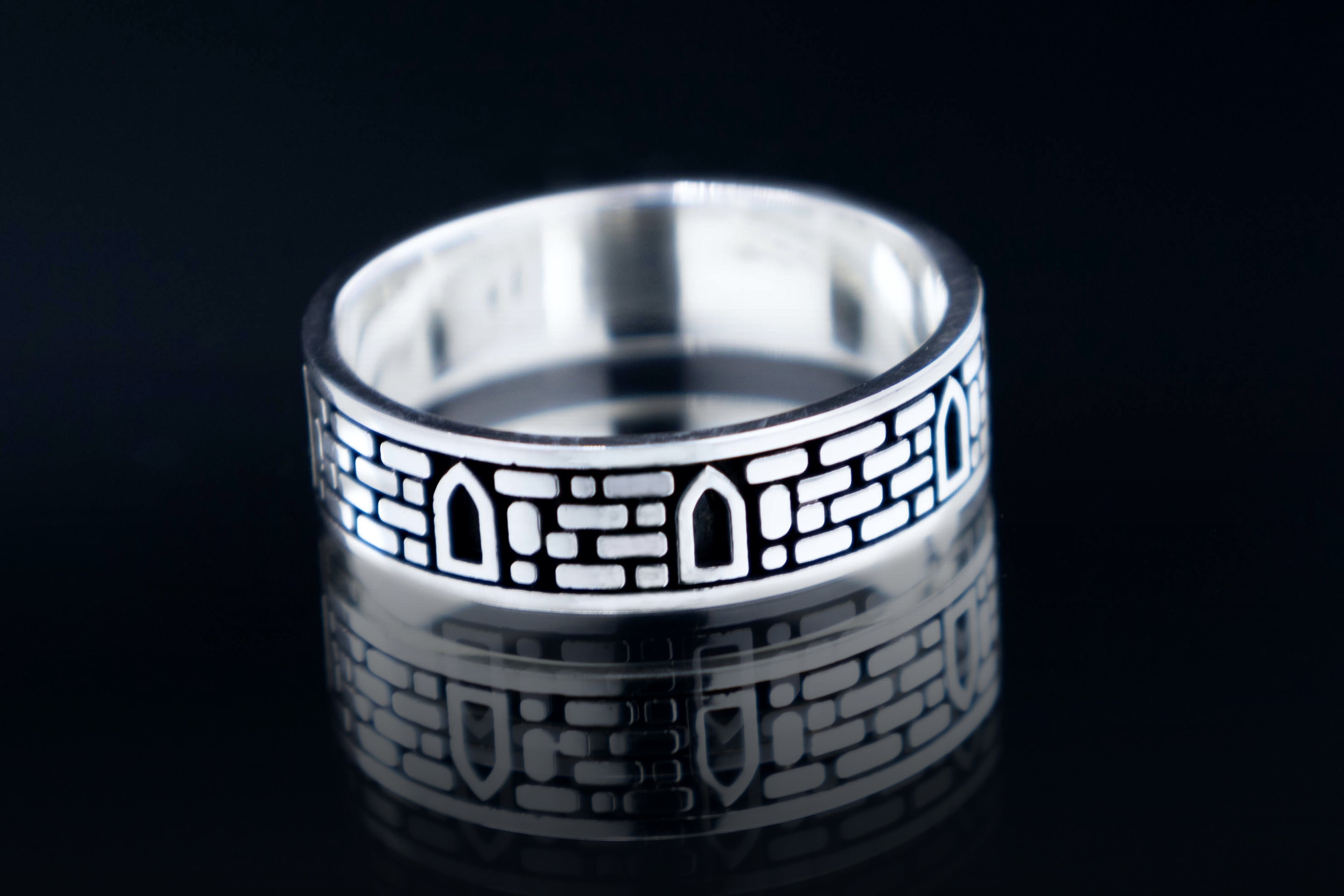 Sterling silver ring with medieval castle stone wall texture and windows, gothic architectural jewelry artifact.