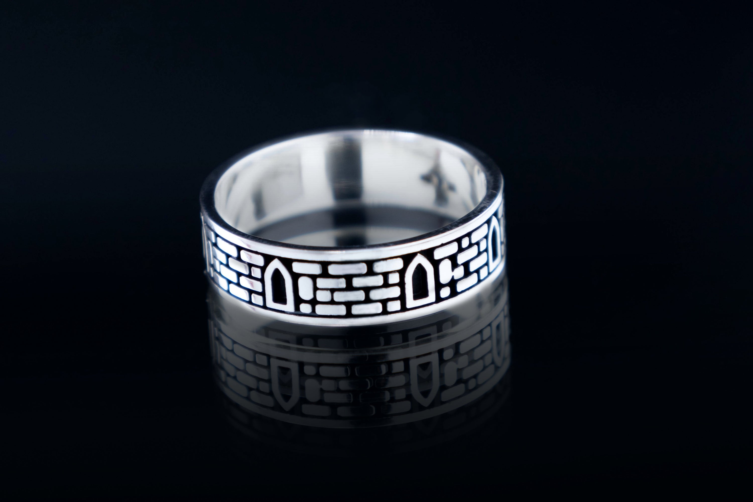 Sterling silver ring with medieval castle stone wall texture and windows, gothic architectural jewelry artifact.