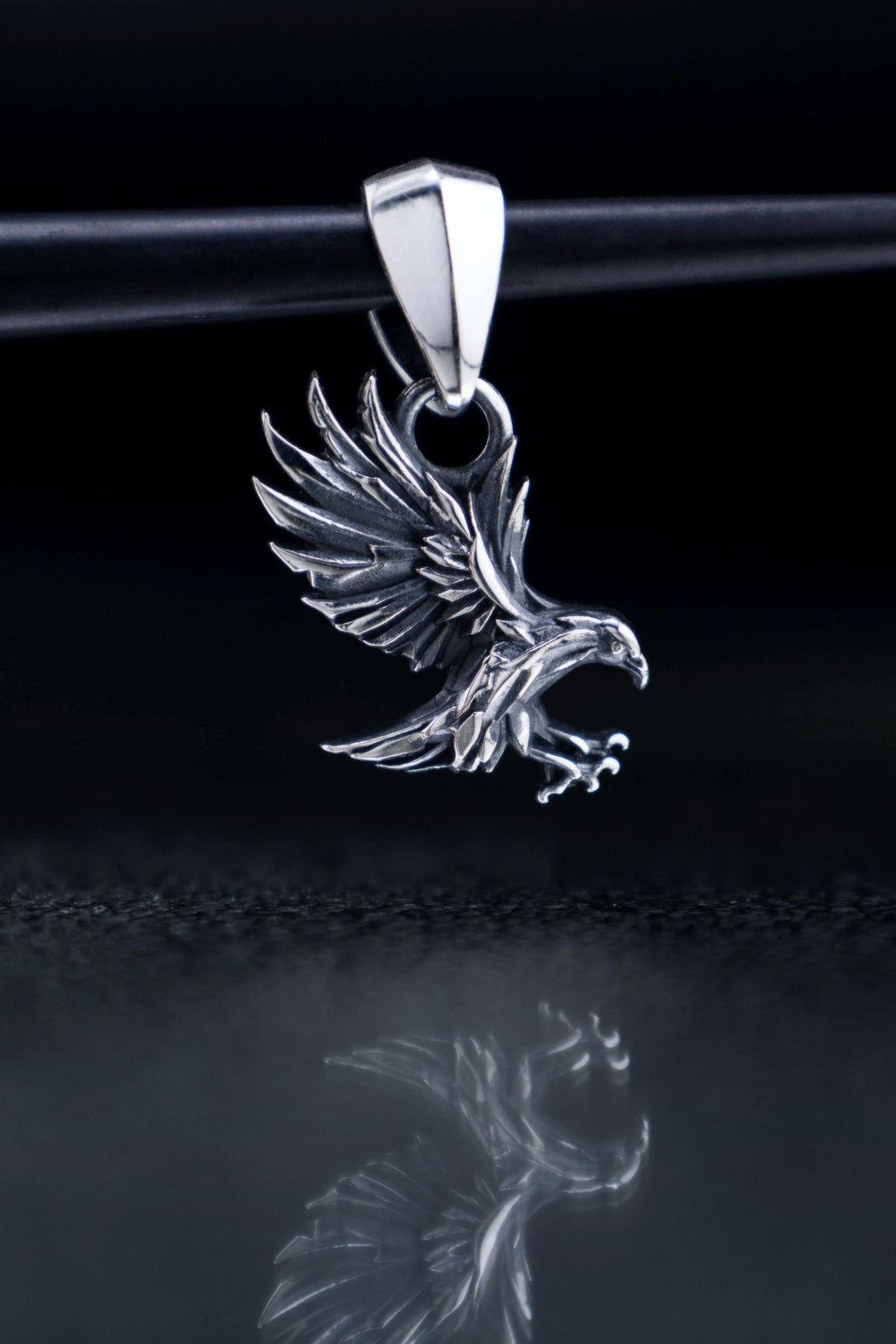 Small 24mm sterling silver raven pendant shown for scale, delicate gothic bird charm with faceted garnet bail, spiritual forest animal jewelry.