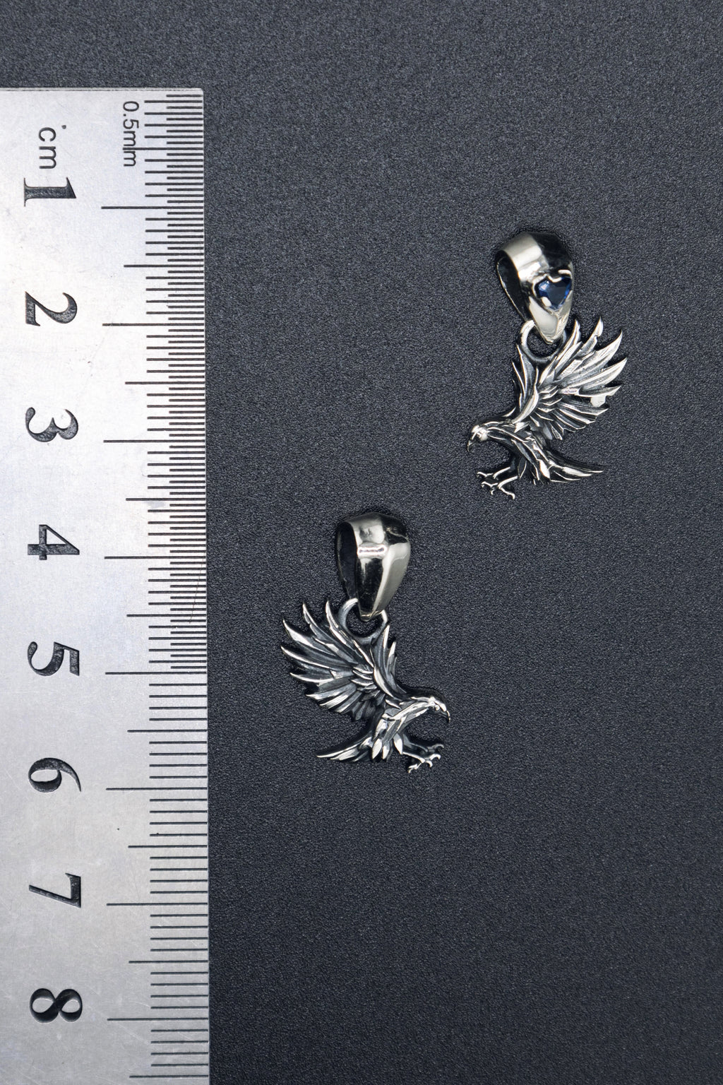 Small 24mm sterling silver raven pendant shown for scale, delicate gothic bird charm with faceted garnet bail, spiritual forest animal jewelry.