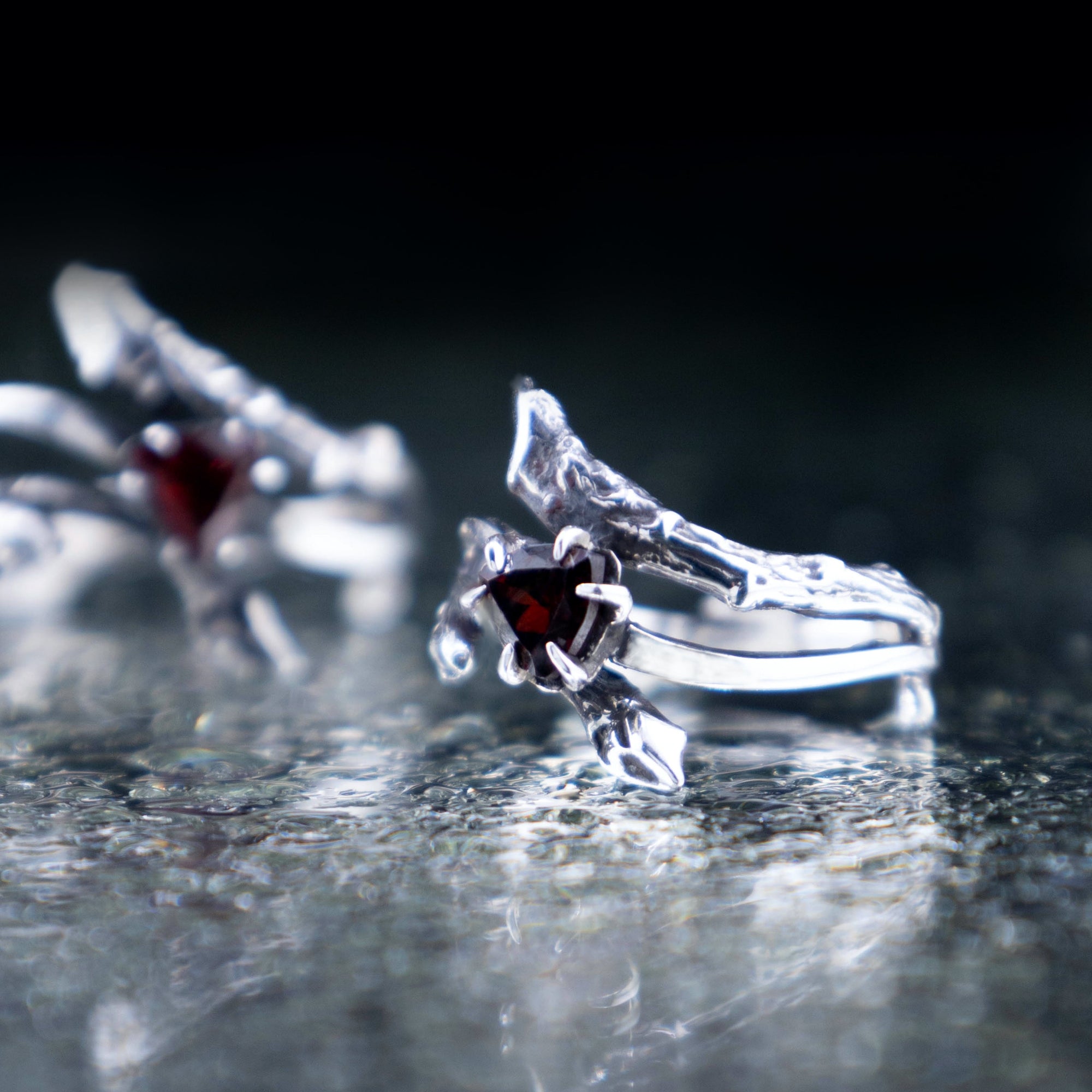 Silver tree branch ring featuring a triangular red garnet crystal, unique elven style gothic engagement ring.
