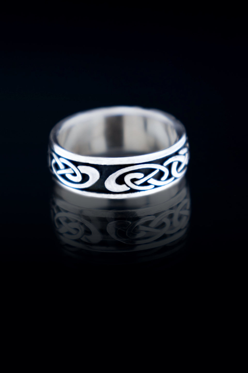 Sterling silver Celtic knot ring detail, oxidized finish on dark background