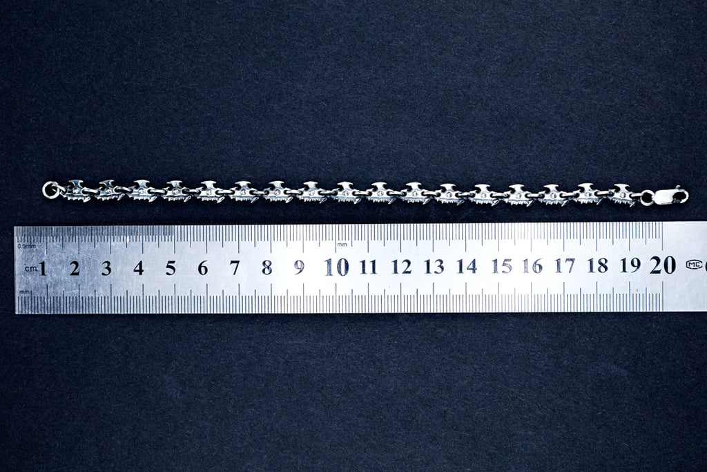 Oxidized silver chain bracelet laid flat next to ruler, showing 19 cm length