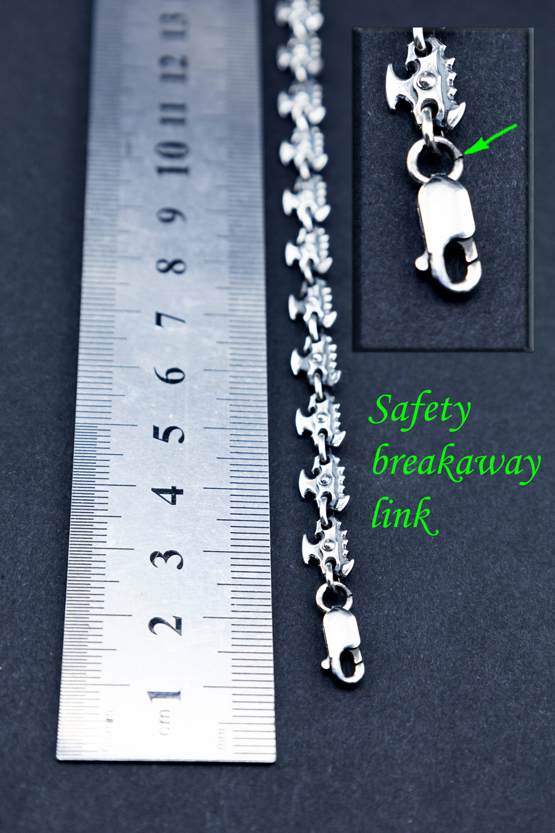 Silver chainsaw chain bracelet with ruler showing safety breakaway link detail