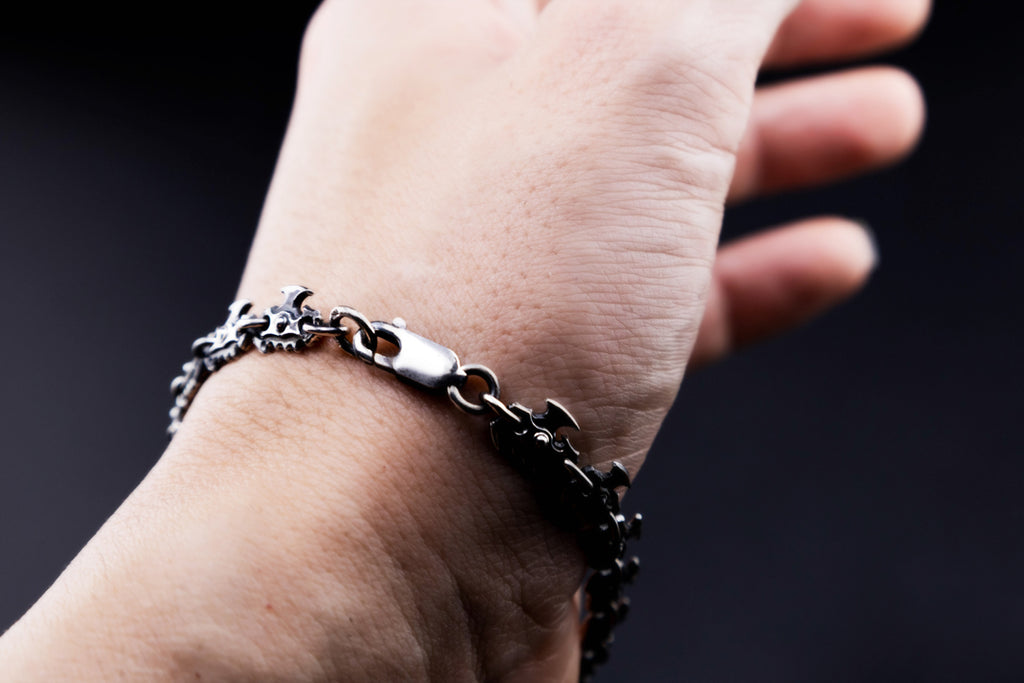 Close-up of the handmade 925 silver bracelet showing its lobster clasp, connecting rings, rivet details, and oxidized serrated links