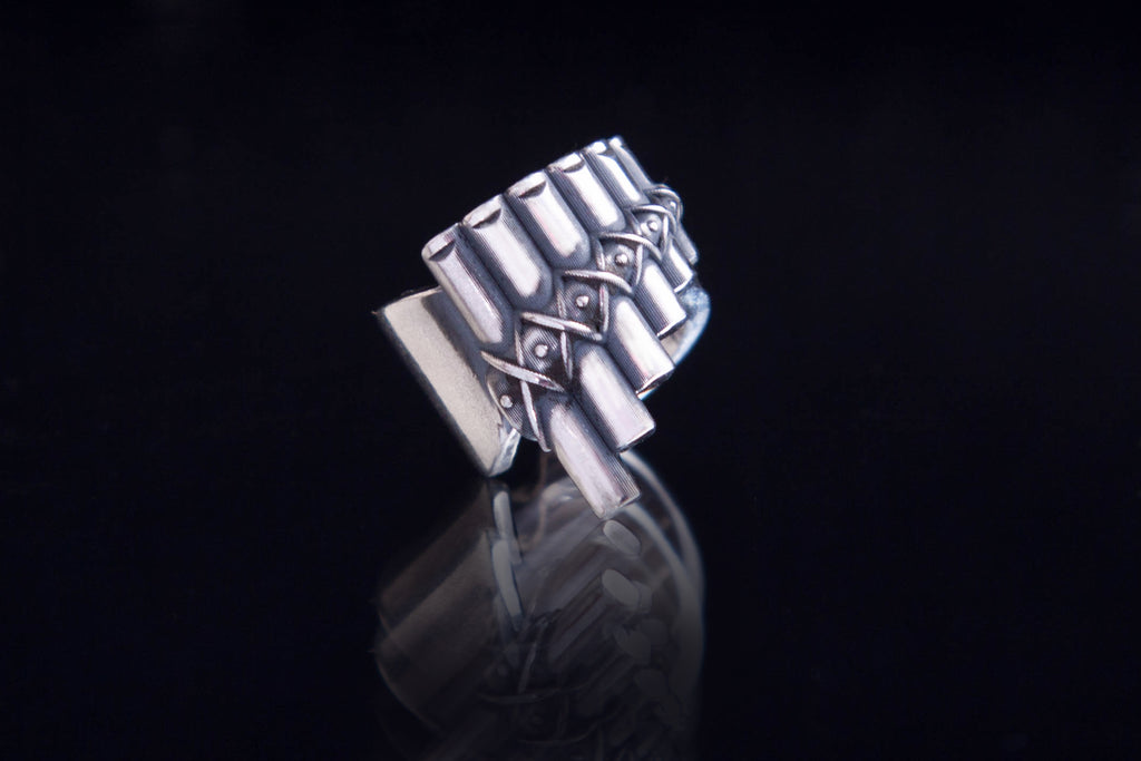 Sculptural silver ear cuff inspired by ancient music and folk instruments