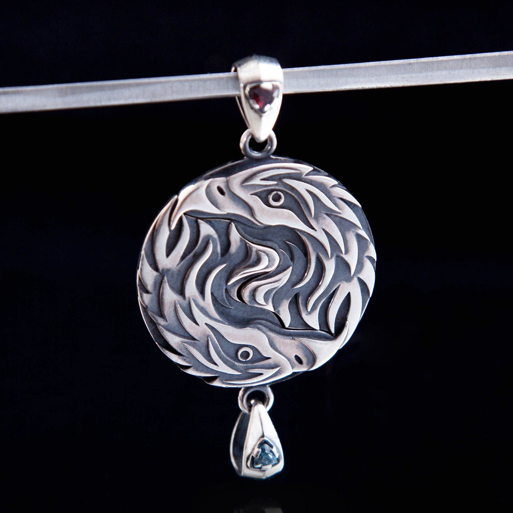 Matching sterling silver eagle pendants displayed side by side