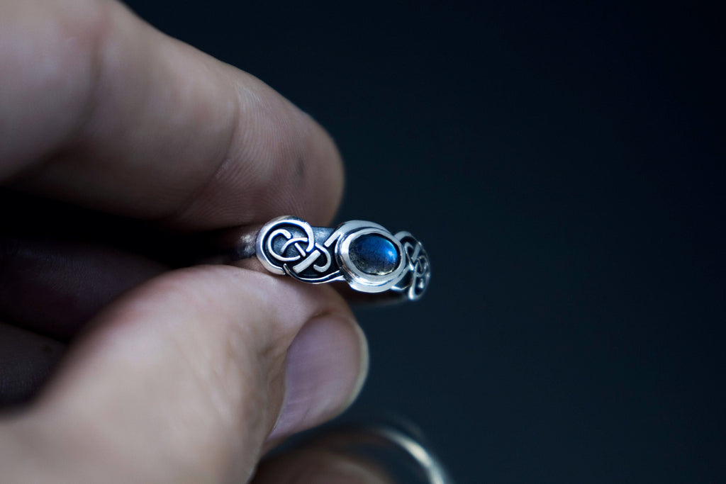 Hand holding Celtic sterling silver labradorite ring