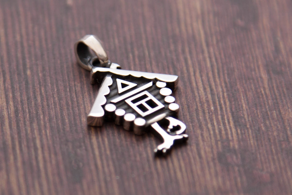 Baba Yaga house necklace styled on wood background