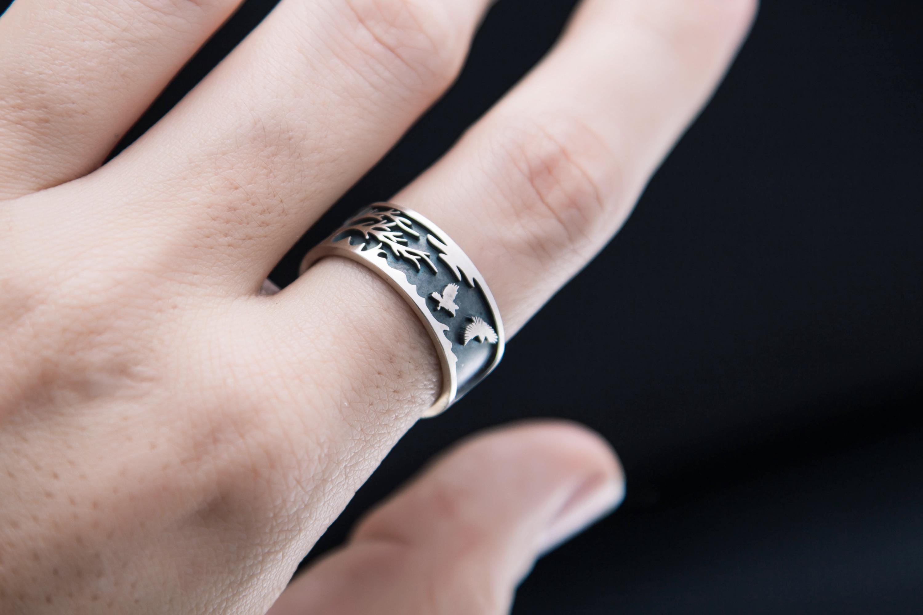 Hand wearing tree and raven sterling silver ring