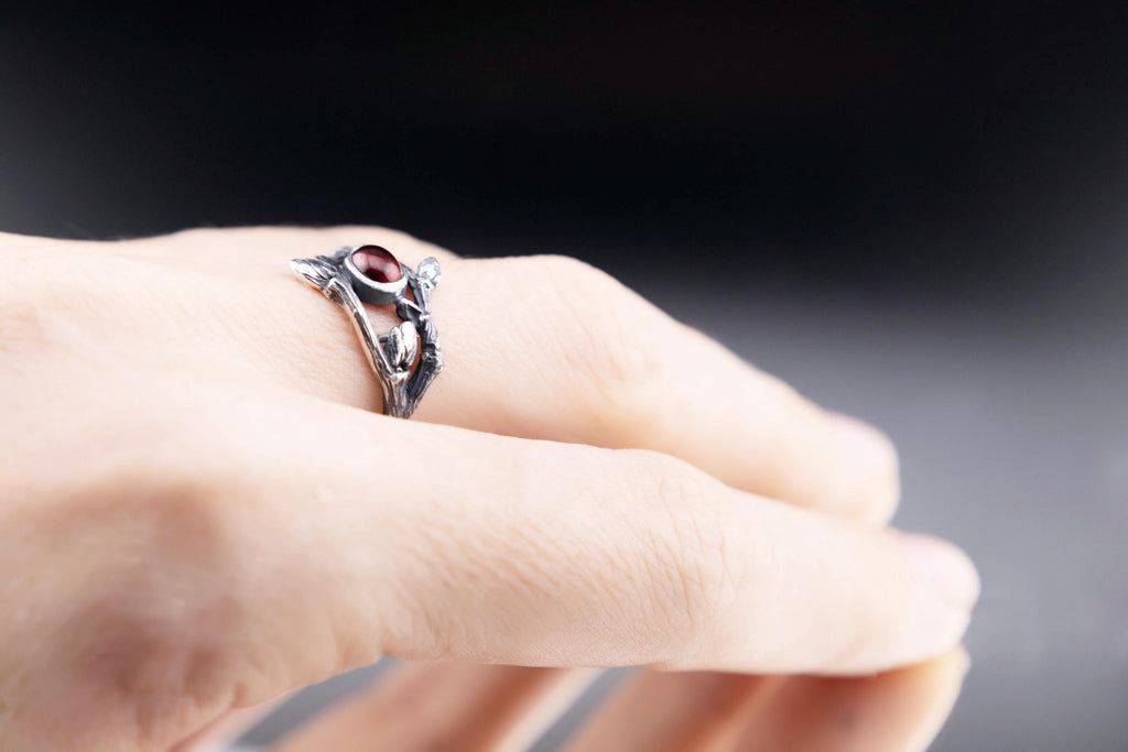 Botanical garnet ring worn on a hand