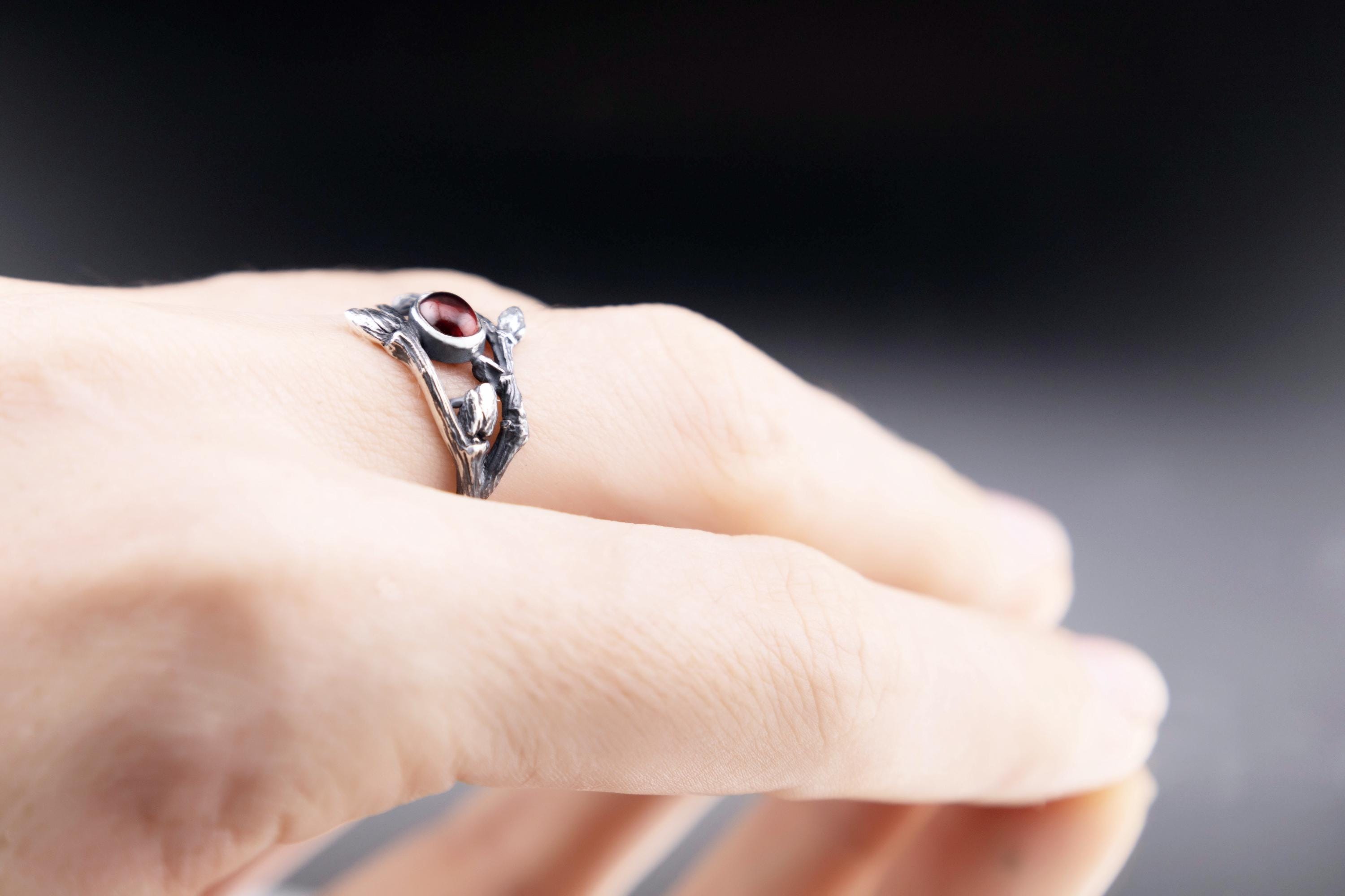 Botanical garnet ring worn on a hand