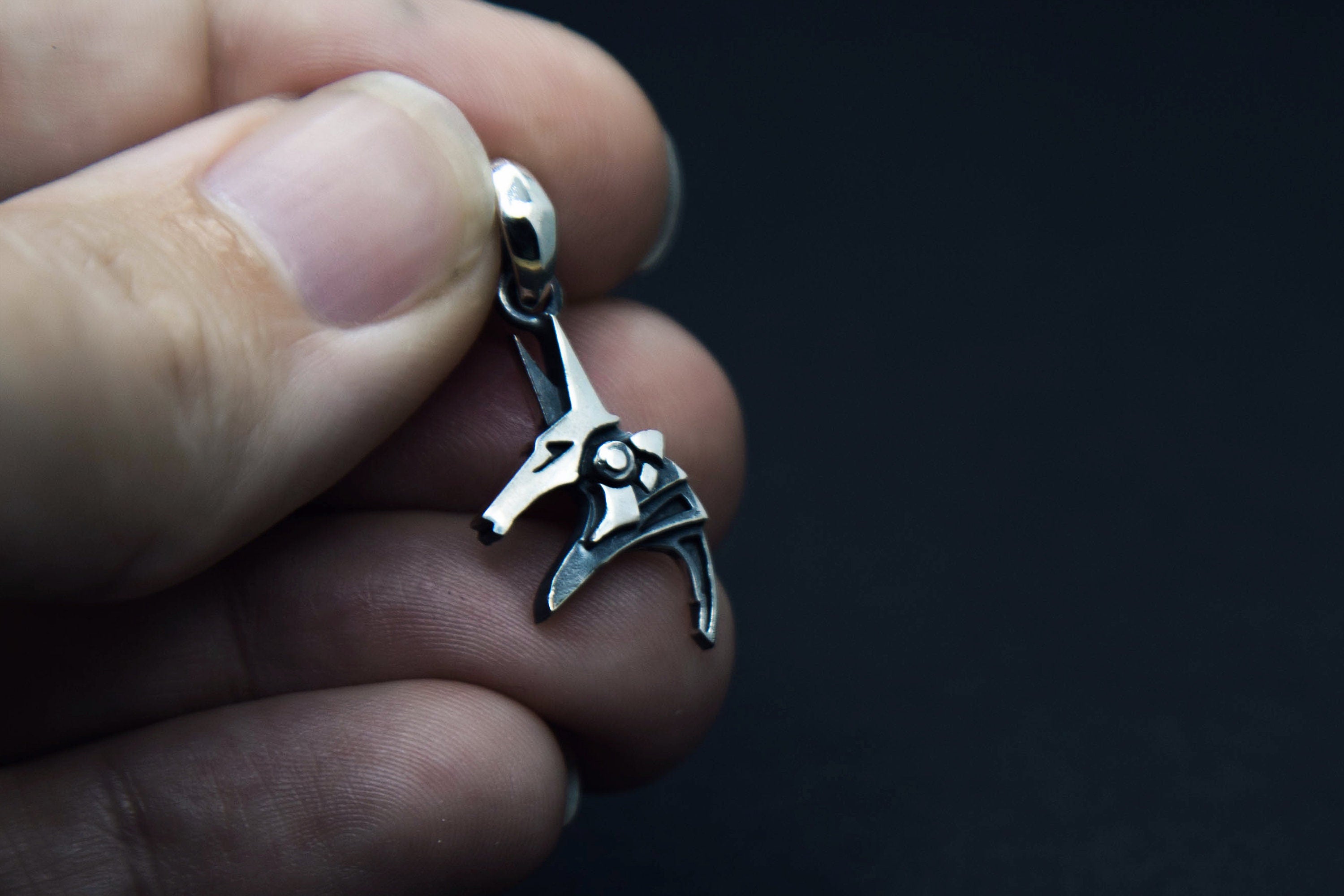 Anubis pendant held in hand, size reference