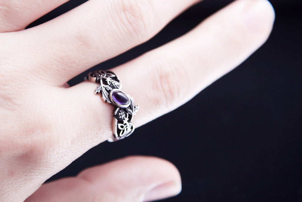 Hand wearing sterling silver thistle ring with natural amethyst