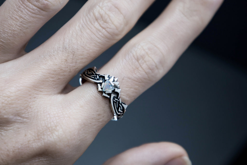 Detailed sculpted silver ring with glowing opal