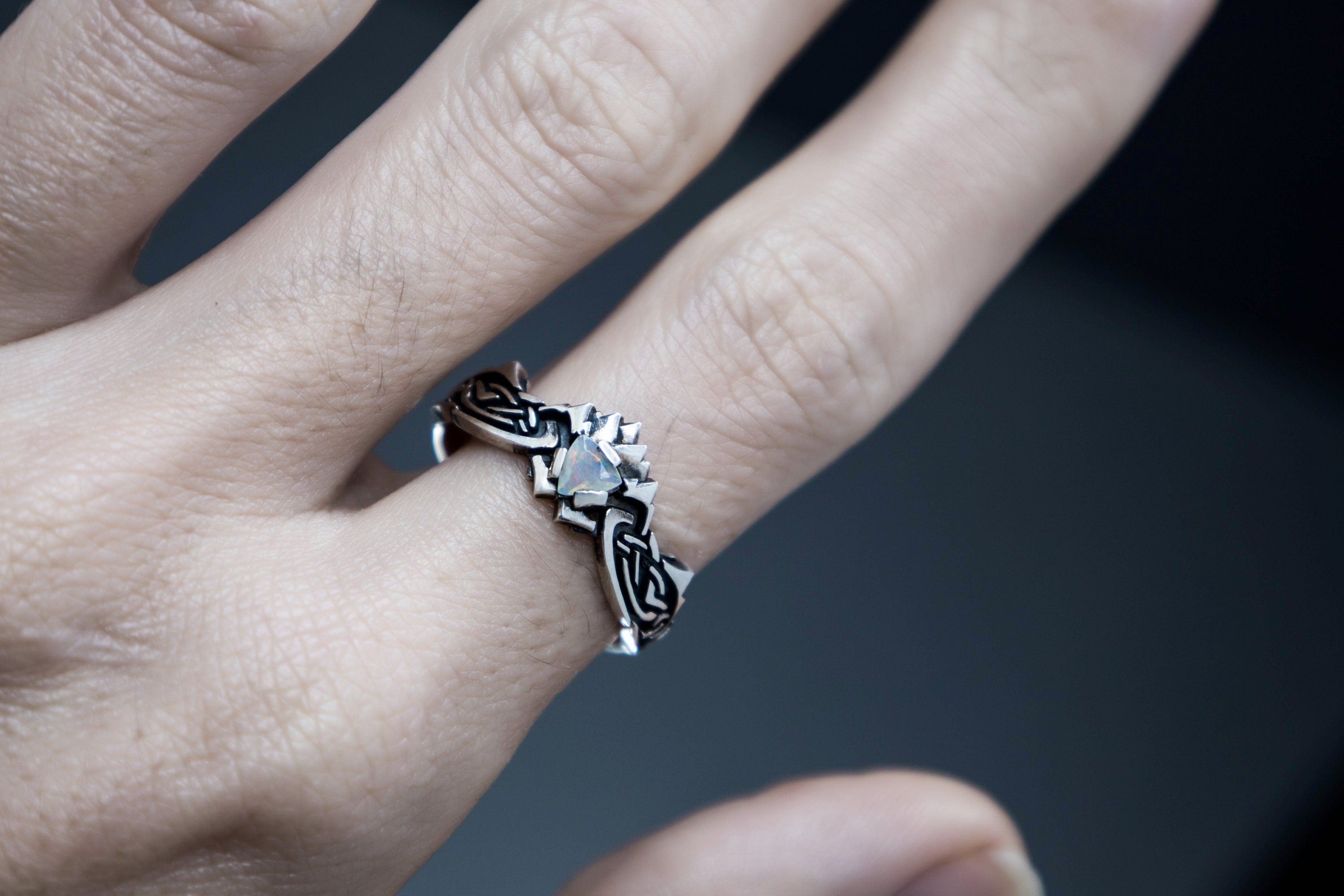 Detailed sculpted silver ring with glowing opal